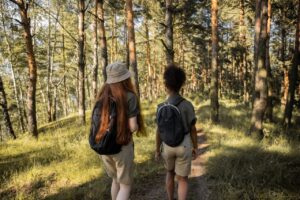 Girls with Backpacks Walking in Forest